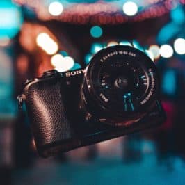 Black Sony camera floating in front of a lit street at night