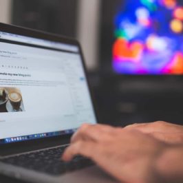 Open laptop with WordPress on screen, hands typing on keyboard