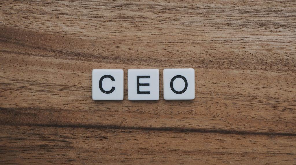 Letter tiles spelling out CEO on wooden background