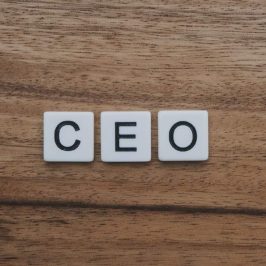 Letter tiles spelling out CEO on wooden background