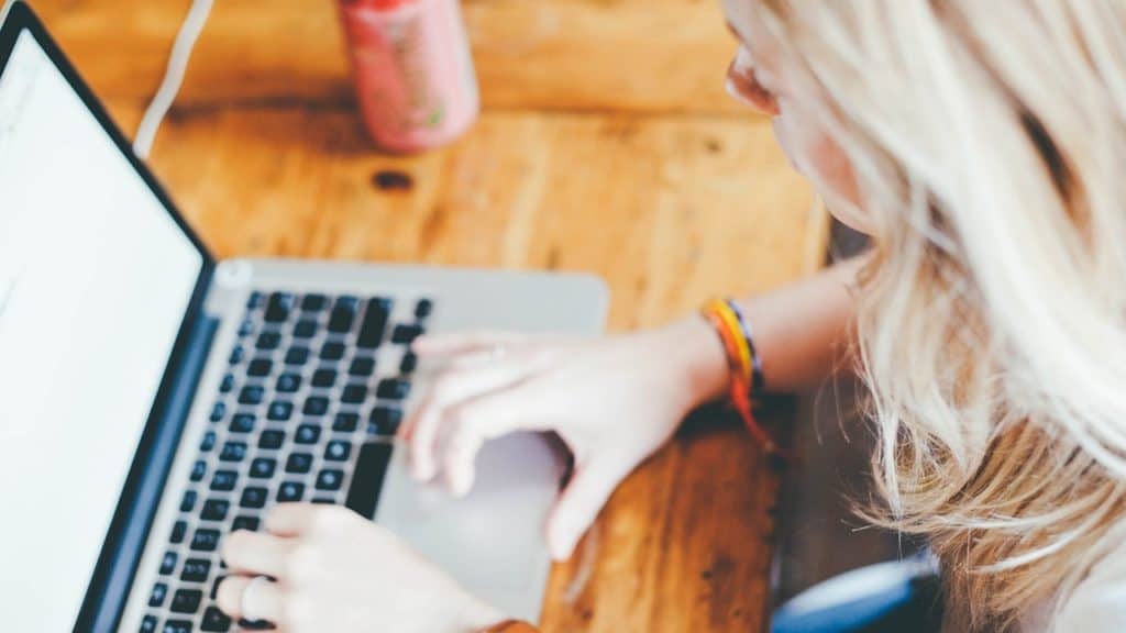 Blonde woman typing on laptop